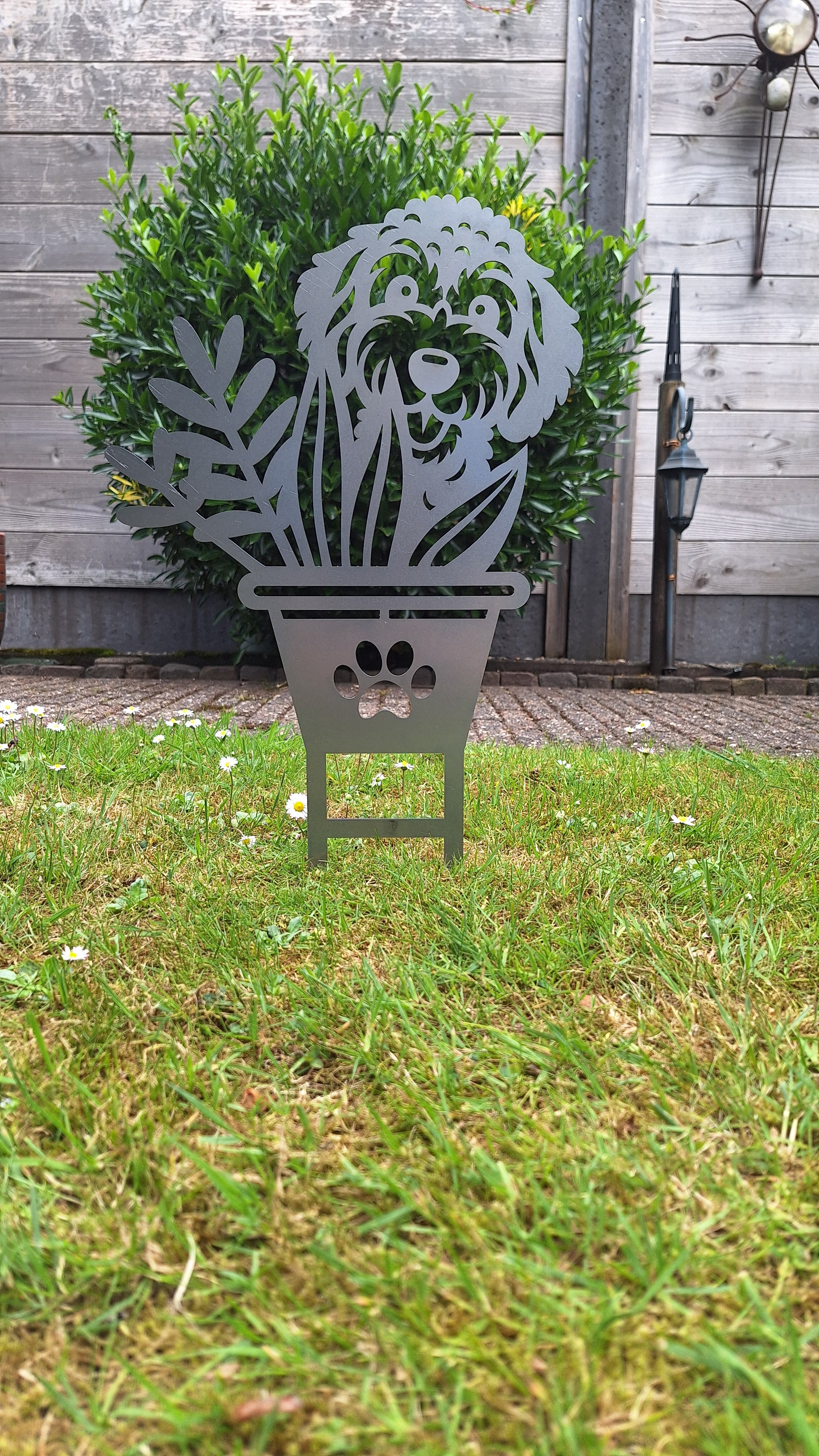 Vrolijke honden tuinprikker Boefje in de Bloempot, gemaakt van cortenstaal, ideaal voor bloemperken en tuinaccessoires.